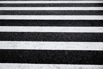 Fototapeta premium Crosswalk surface background,top view. pedestrian crossing, white stripes on black asphalt, zebra crossing