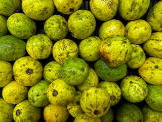 Fresh Guava Fruit on sale in a Fresh fruit market. Top view of green and yellow common guava.