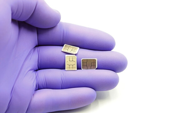 Gloved hand holding mobile phone SIM cards.Concept of technology and manufacture of computer and electronic components