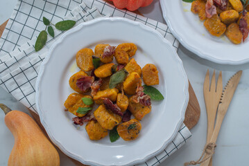 Healthy home made Pumpkin gnocchi with cheese and fresh herbs on a table