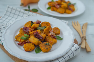 Healthy home made Pumpkin gnocchi with cheese and fresh herbs on a table