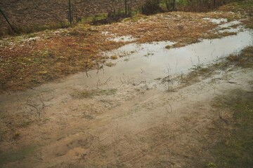 water on the ground. sewage and draining problems. heavy rain in rural areas with water puddles on the soil