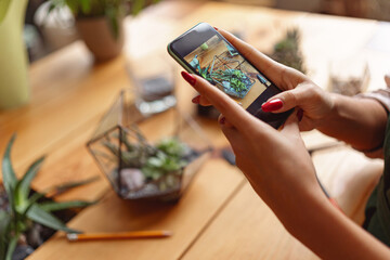 Close up of florist taking picture with her plants for publishing in social media