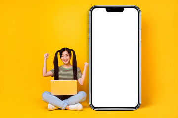 Fototapeta na wymiar Photo of young excited crazy lady raise fists in triumph buy new modern cellphone isolated on yellow color background