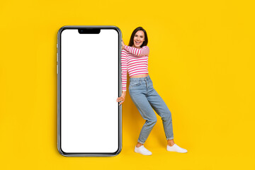 Fototapeta na wymiar Photo of pretty lady arm hold big modern device gadget telephone panel wall mirror empty space isolated on yellow color background