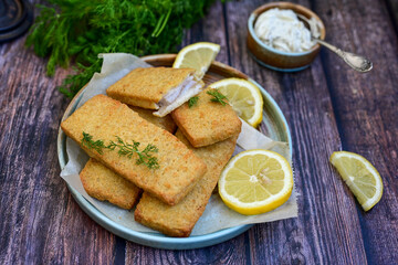   Allasca Pollock Fish  Bites in a crispy Tempura  Batter.Fish and chips .Close up of   crispy breaded  deep fried fish fingers with breadcrumbs s erved with remoulade sauce and  lemon