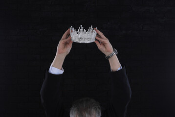 businessman wears a crown, black background