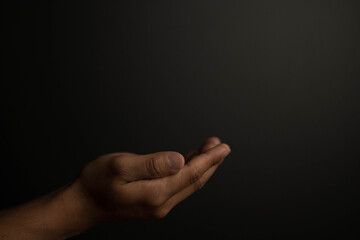Praying hands with faith in religion and belief in God on dark background. Power of hope or love and devotion.