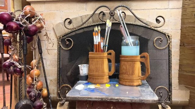 country house home furniture craft wood utensils Handmade furniture artist's workshop two large wooden mugs beer pints with tassels handles lowered down natural pile for working with oil paints