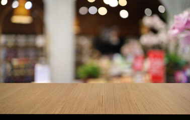 Naklejka na ściany i meble Empty wooden table in front of abstract blurred background of coffee shop . can be used for display or montage your products.Mock up for display of product