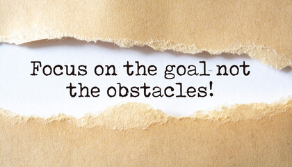 'Focus on the goal not the obstacles' written under torn paper.