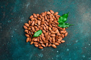 Nut almonds in a wooden bowl. Healthy snacks. On a dark background.