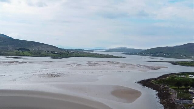 Aerial side slider shot of Achill Sound Achill Island where  award winning film  The Banshees of Inisherin was filmed at low tide in the evening looking west toward Keem Bay