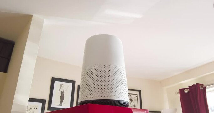 An air purifier sitting in a living room cleaning smoke, dust and pollen etc.  from the air