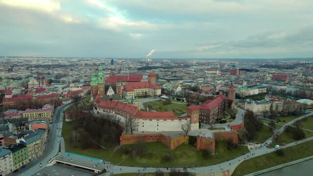 Aerial stablishing shot moving upwards revealing the city of Krakow, Poland, with the Wawel Royal Castle and the city center in the background. Drone aerial.