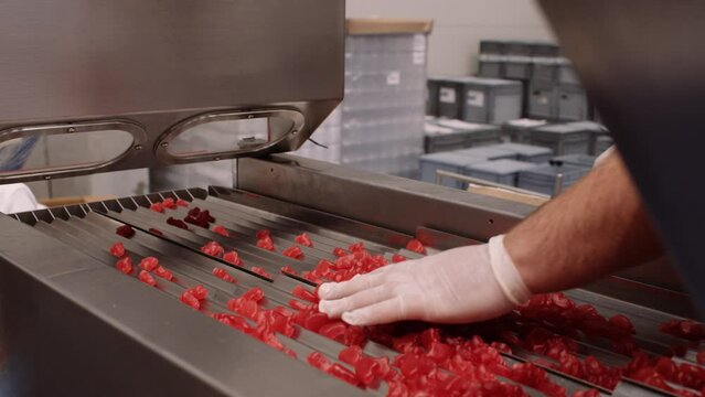 Red multivitamin gummy supplements spread out on chutes - nutraceutical industry