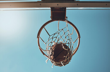 Basketball, net and ball below in sports game outdoors for sports match in the USA. Sport and airball of throw to score point for win, victory against fiberglass board with blue sky background