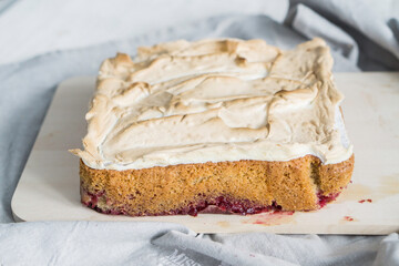 Layer sheet cake with merengue with cut piece of cake white color selevtive focus close up