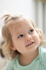 toddler girl smile and looks upward, authentic joy, bright vertical concept