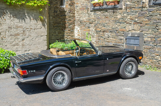 A black Triumph TR6 convertible on a beautiful summer day