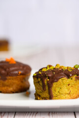 Two muffins with chocolate and nuts on top