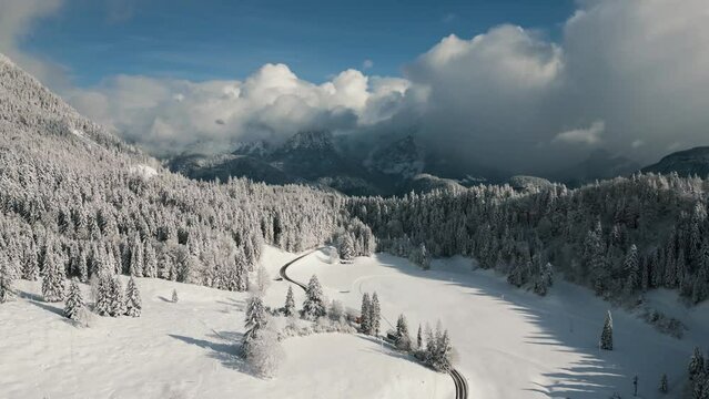 Mountain ridge snowy landscape with snow, sunlight and blue sky. Aerial drone view flying over empty cinematic alpine winter scenery valley in Austria Bavaria alps mountains 4K UHD epic documentary