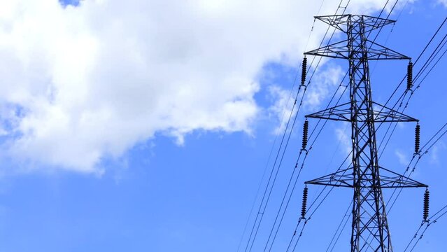 power lines. blue sky with clouds. cloud timelipse bright blue sky background. white cloud hyperlipse. summer weather in the countryside. no people.
