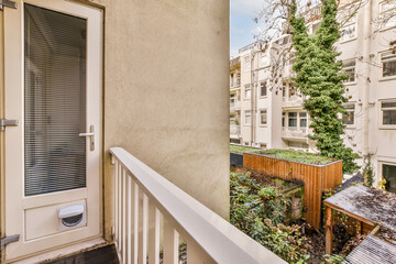 an outside area with a door, window and planter on the right hand side of the apartment's balcony