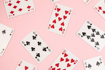 Poker playing cards on pink background