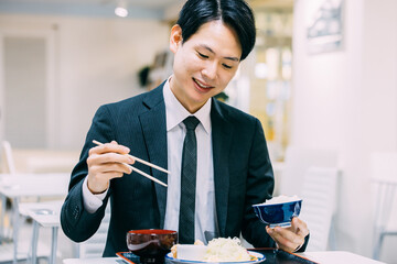 定食を食べる日本人男性ビジネスマン
