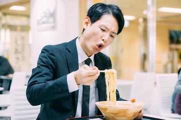 ラーメンを食べる日本人男性ビジネスマン