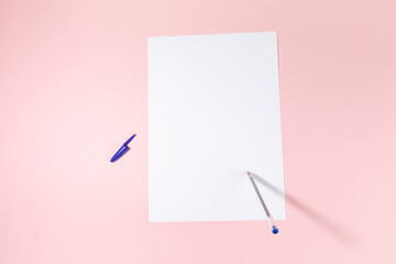empty white paper sheet and a pen on pink background. Mockup