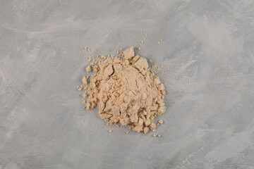Pile of Soy Protein isolate on grey textured background, top view. Superfood. Pure powder isolated...