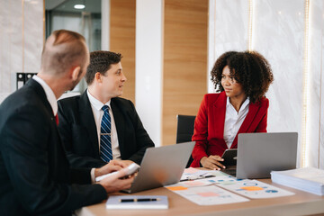 Happy businesspeople while collaborating on a new project in an office. Group of diverse businesspeople using a laptop and tablet in office..