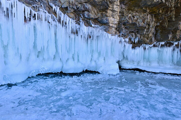 Rock Cliff Covered with Icicles and Snow During Winter at Lake Baikal