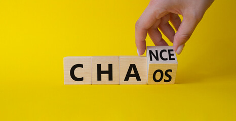 Chance vs Chaos symbol. Businessman hand Turnes cube and changes word Chaos to Chance. Beautiful yellow background. Psychology and Chance vs Chaos concept. Copy space