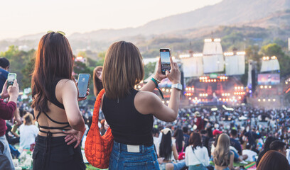 Women stand in the park, Watch a concert at Open Air Music Festival.
