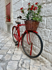 bicycle with red flowers in front of a brick wall