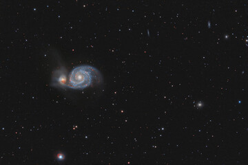 Naklejka na ściany i meble Galaxy M51 photographed through a telescope. Photo of real outer space. Stars and galaxies on a dark background.