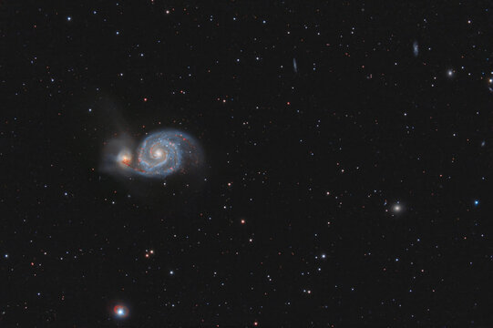 Galaxy M51 photographed through a telescope. Photo of real outer space. Stars and galaxies on a dark background.