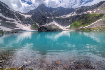 Soft focus. Super wide angle shot. Mountain peaks covered with snow. Lakes with clear blue water.