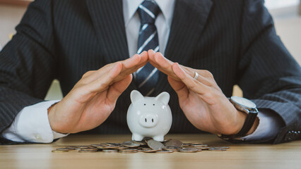 Businessman protect the piggybank in hand, donation, saving, charity, family finance plan concept,...