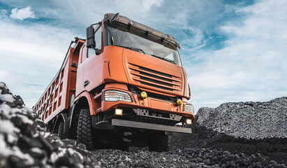 Large quarry dump truck. Dump truck carrying coal, sand and rock. Trucks moving on dirt country...