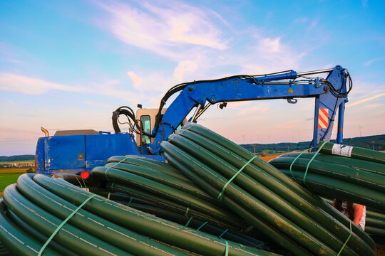  equipment for water supply.Water pipes and construction installation equipment in the field.Carrying out water construction work.Plumbing installation.Blue excavator with pitchforks