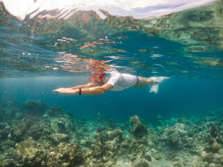 woman snorkeling in clear tropical sea