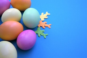 Colorful Easter eggs. Banner, wallpaper, postcard, social media post with copy space for text. Painted eggs arranged on one side on a blue background
