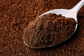 Ground coffee in spoon close-up.