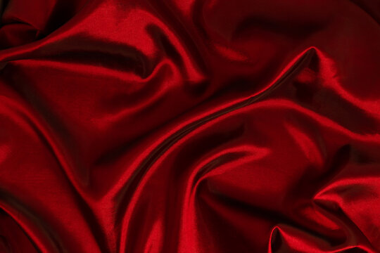 Abstract dark red background, luxury cloth or liquid wave, wavy folds of grunge silk texture satin velvet material or luxurious Christmas background. Elegant wallpaper design.