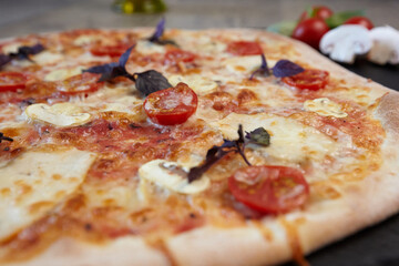Delicious traditional Italian Margarita pizza with cheese, tomato sauce and herbs on a wooden board