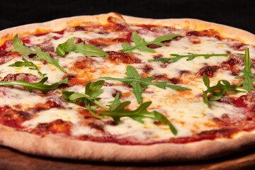 Delicious traditional Italian Margarita pizza with cheese, tomato sauce and herbs on a wooden board